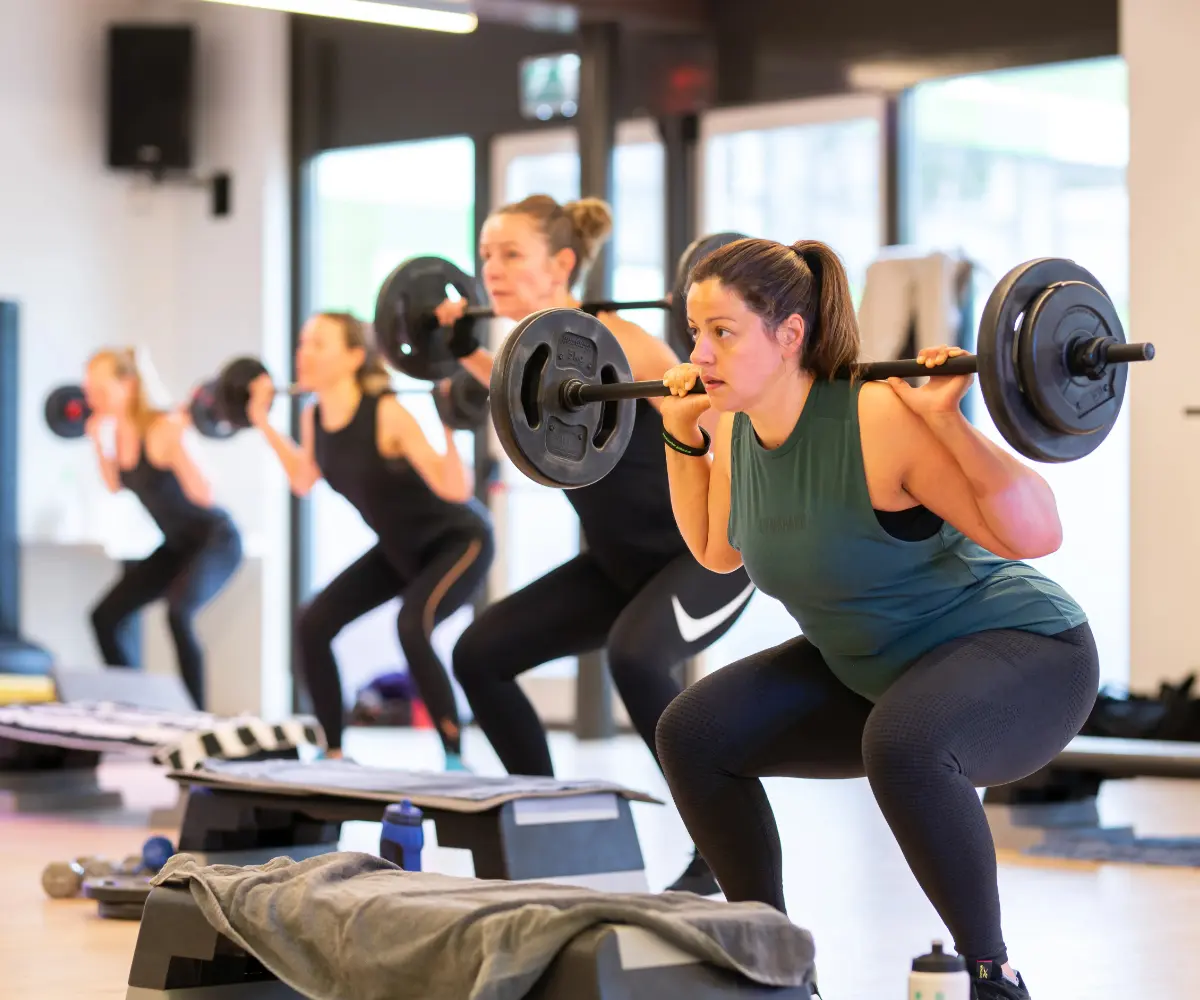 Groep vrouwen die meedoen aan de groepsles BodyPump